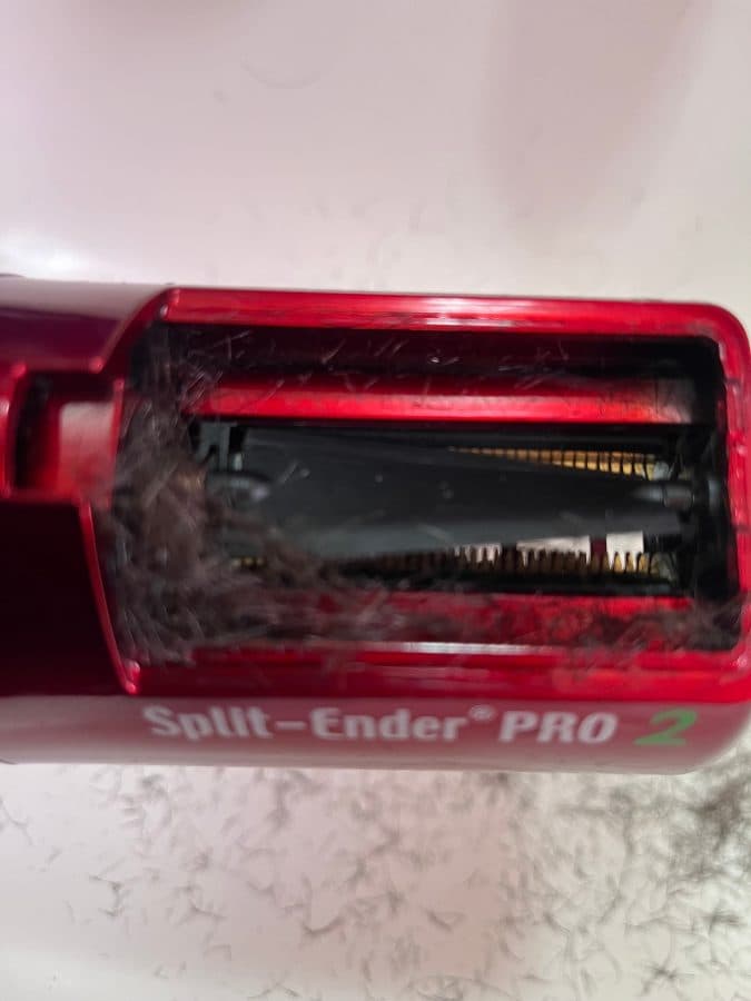 A red Split Ender PRO2 with removed hair behind the chamber window